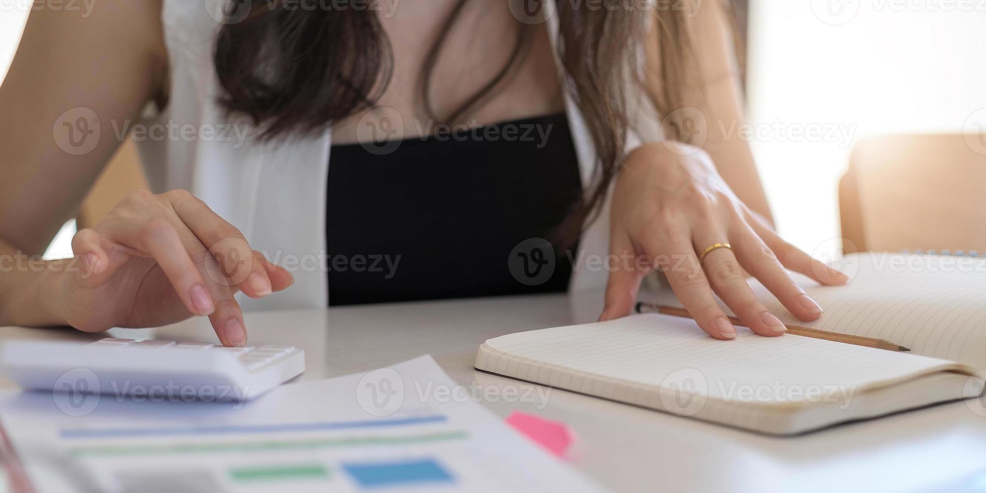 close-up zakenman met behulp van rekenmachine en laptop voor het berekenen van financiën, belastingen, boekhouding, statistiek en analytisch onderzoeksconcept foto