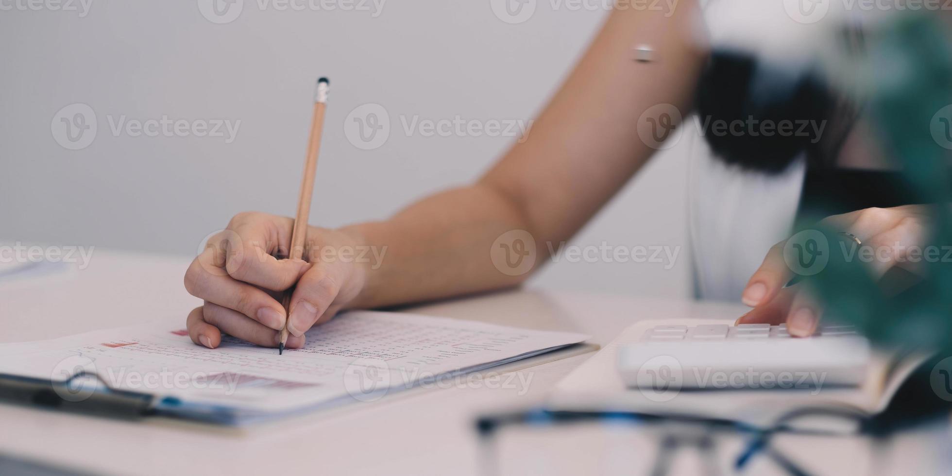 close-up zakenman met behulp van rekenmachine en laptop voor het berekenen van financiën, belastingen, boekhouding, statistiek en analytisch onderzoeksconcept foto