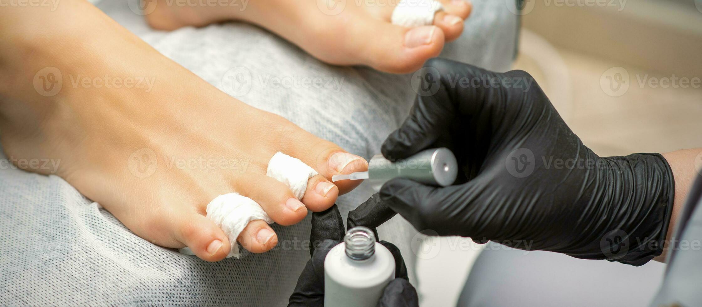 pedicure toepassen transparant vernis naar de vrouw teennagels in een schoonheid salon. foto