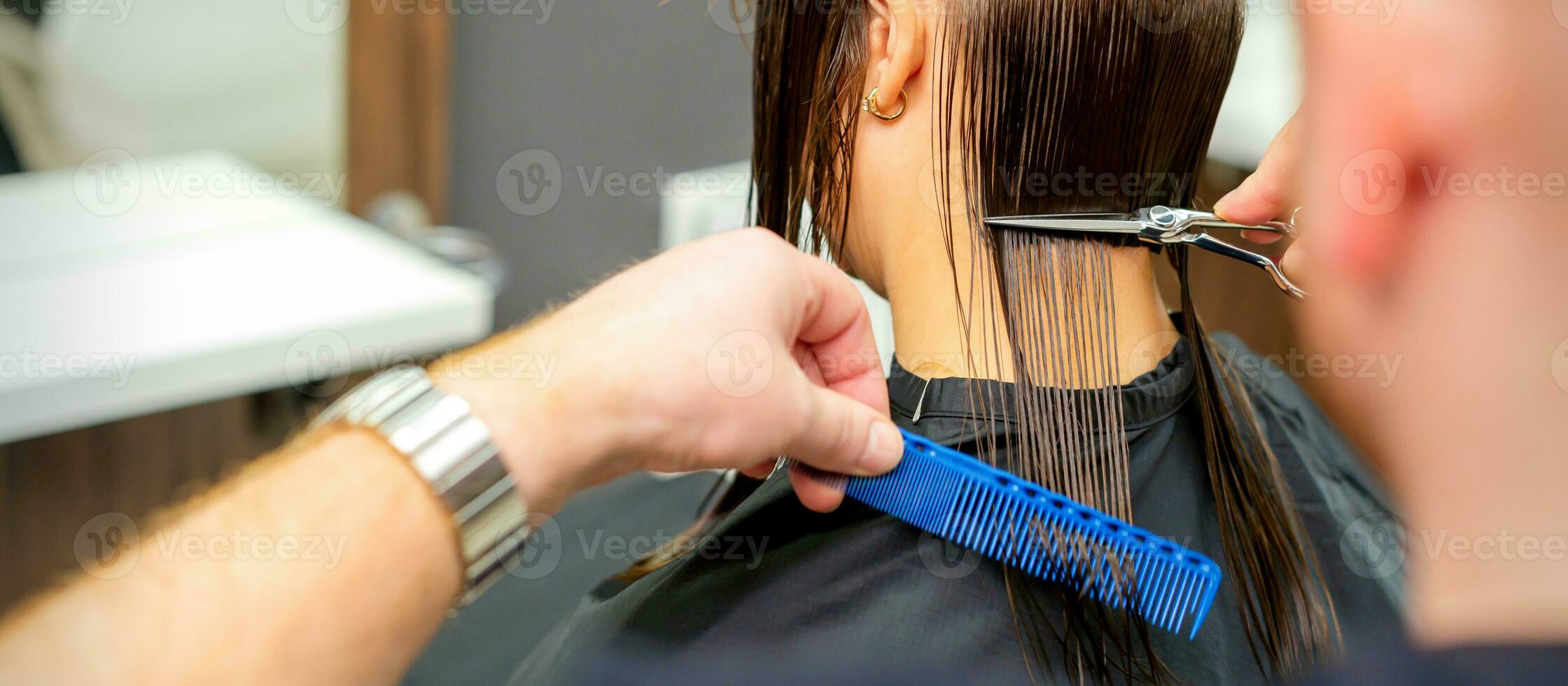 de mannetje kapper bezuinigingen terug vrouw van de klant haar- met schaar en kam in een schoonheid salon. foto