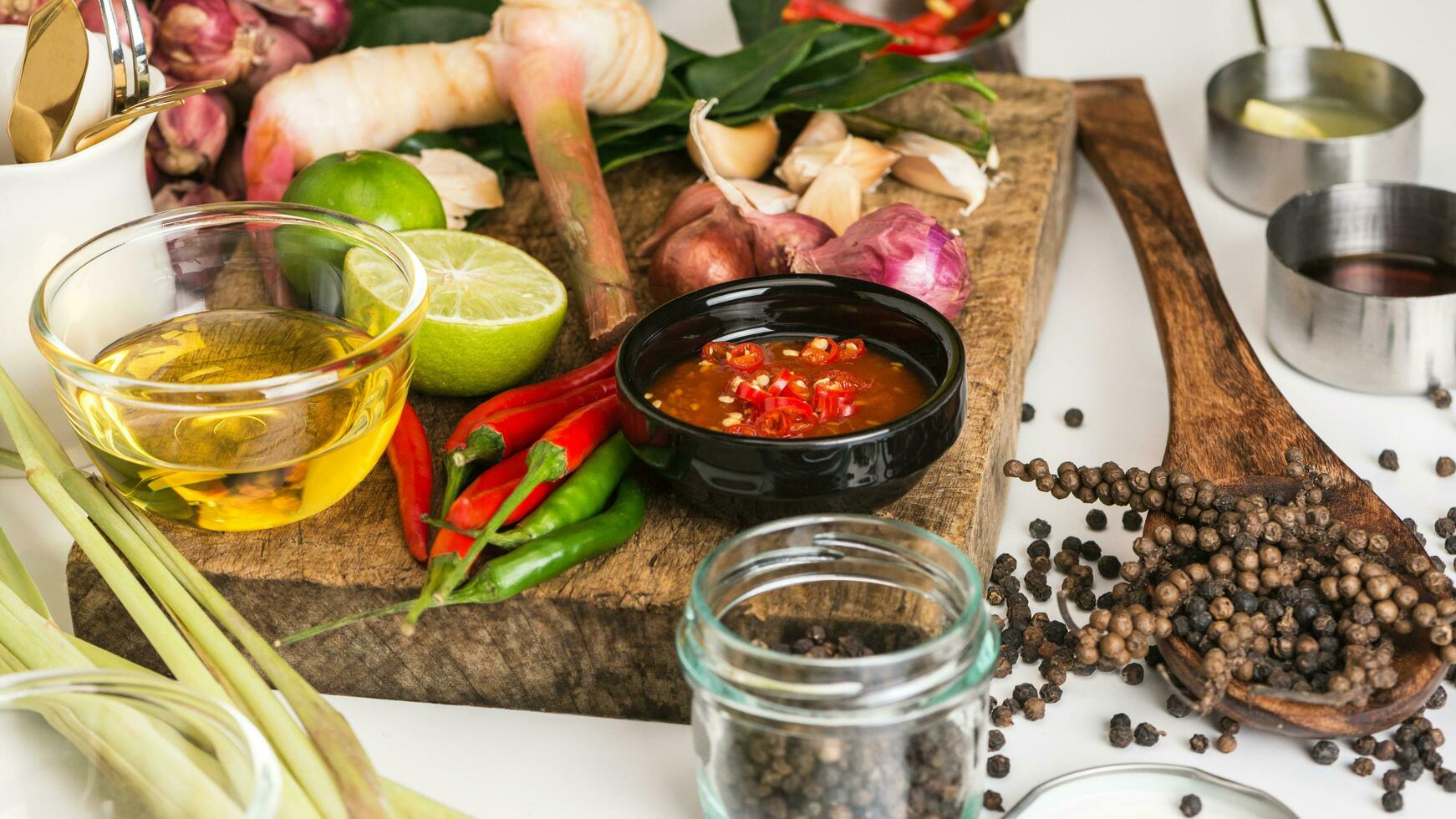 specerijen voor gebruik als kookingrediënten op een houten ondergrond met verse groenten. gezonde voeding kruiden. biologische groenten op tafel. grondstoffen van kookvoorbereiding tom yum. foto