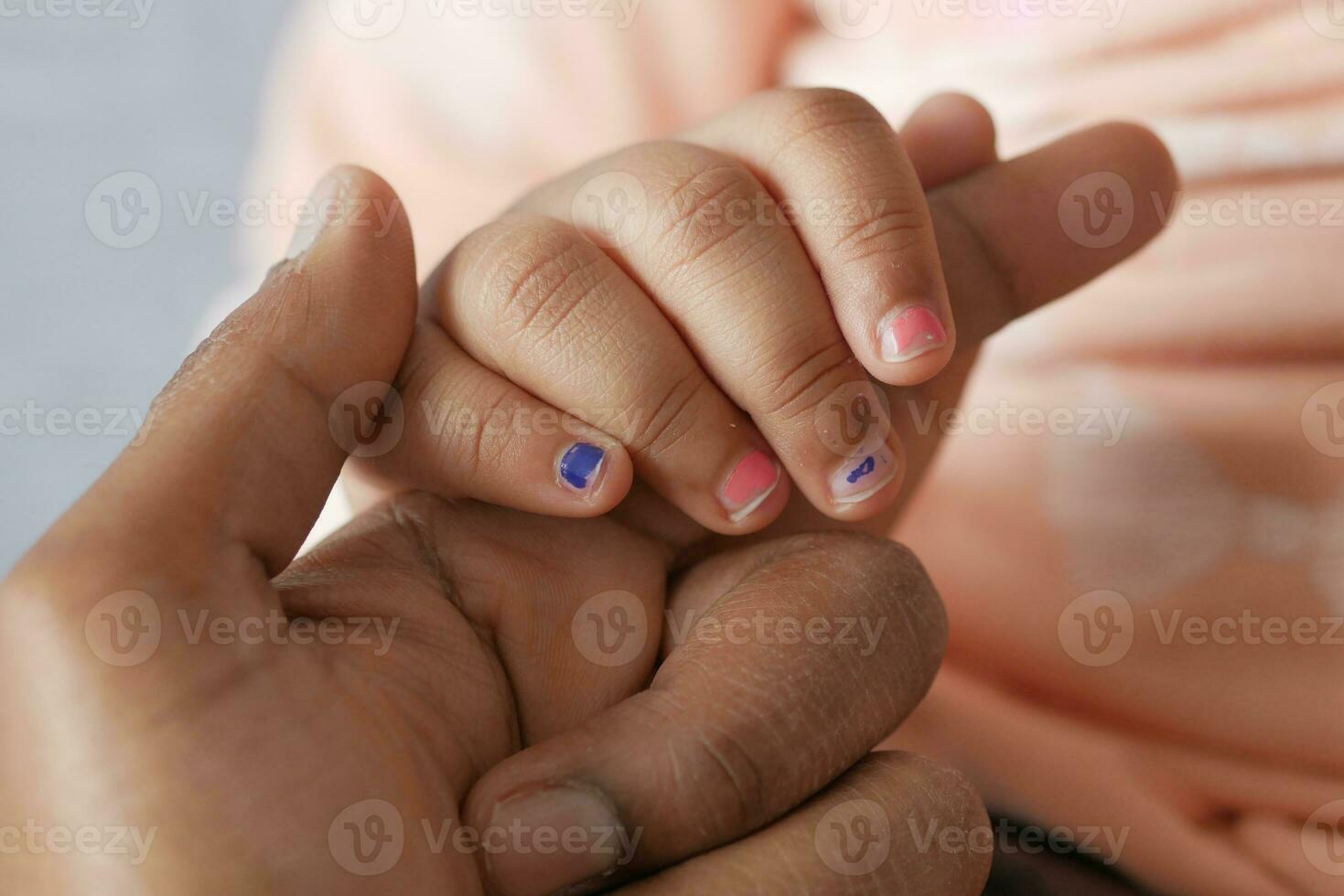 vader die de hand van het babykind vasthoudt, close-up. foto