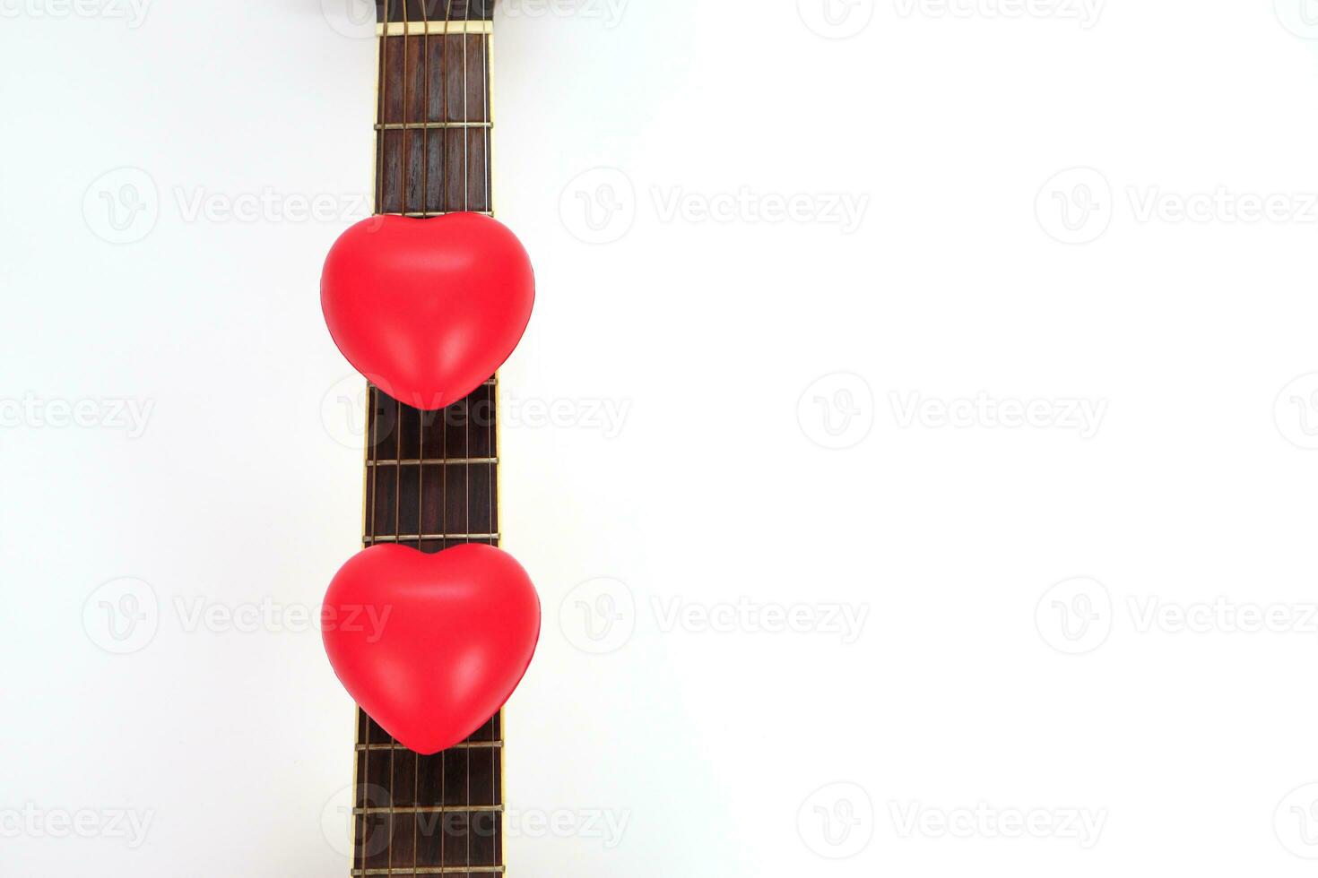 akoestisch gitaar nek en rood hart tegen wit achtergrond. liefde, kom tot rust en muziek- concept. foto