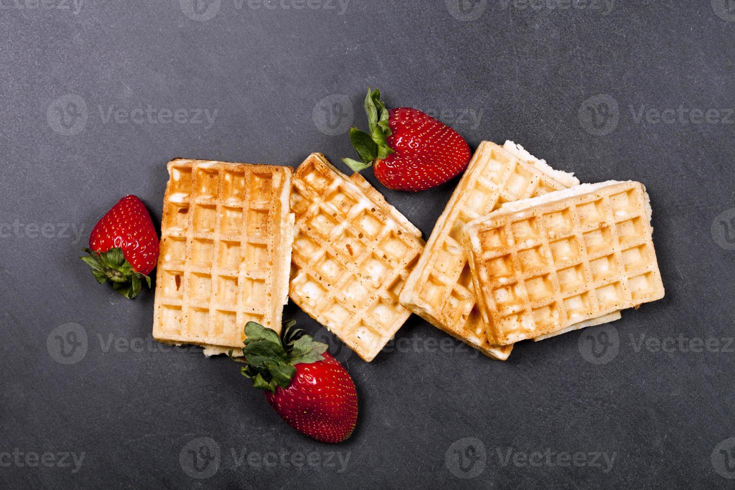 belgische wafels en aardbeien op zwarte bordachtergrond. foto