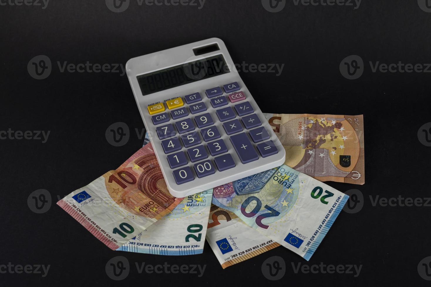 bankbiljetten met rekenmachine om te tellen foto