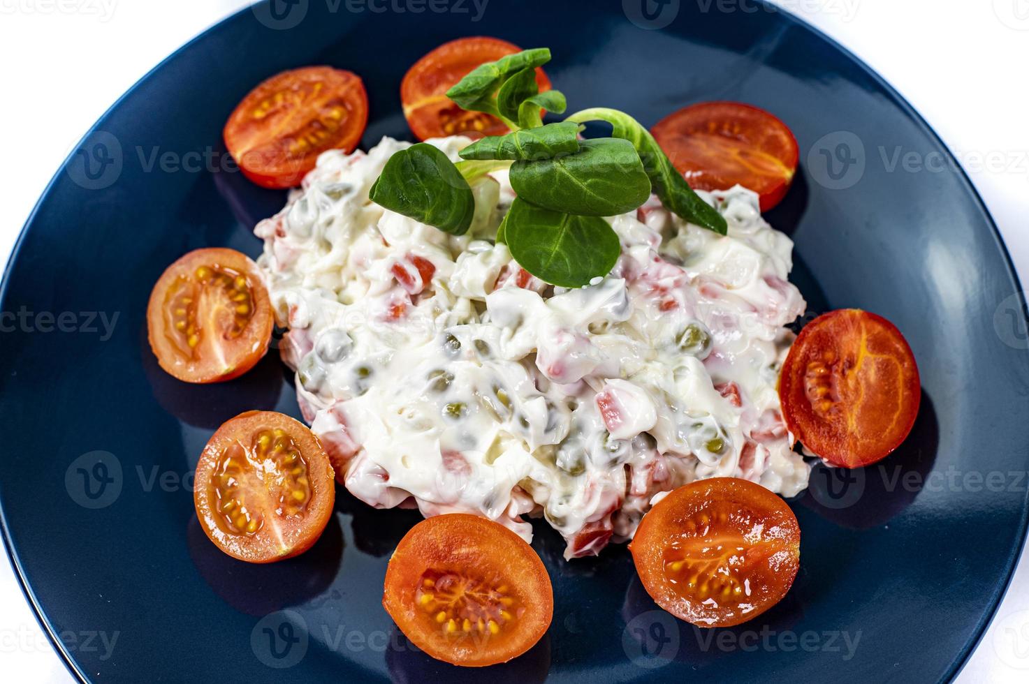 Russische salade op blauw bord foto