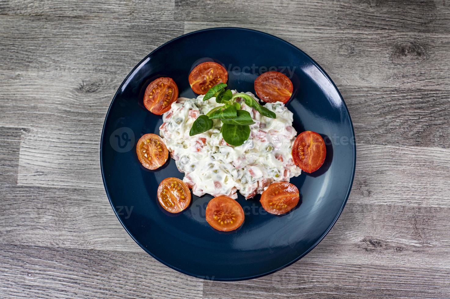 Russische salade op blauw bord foto