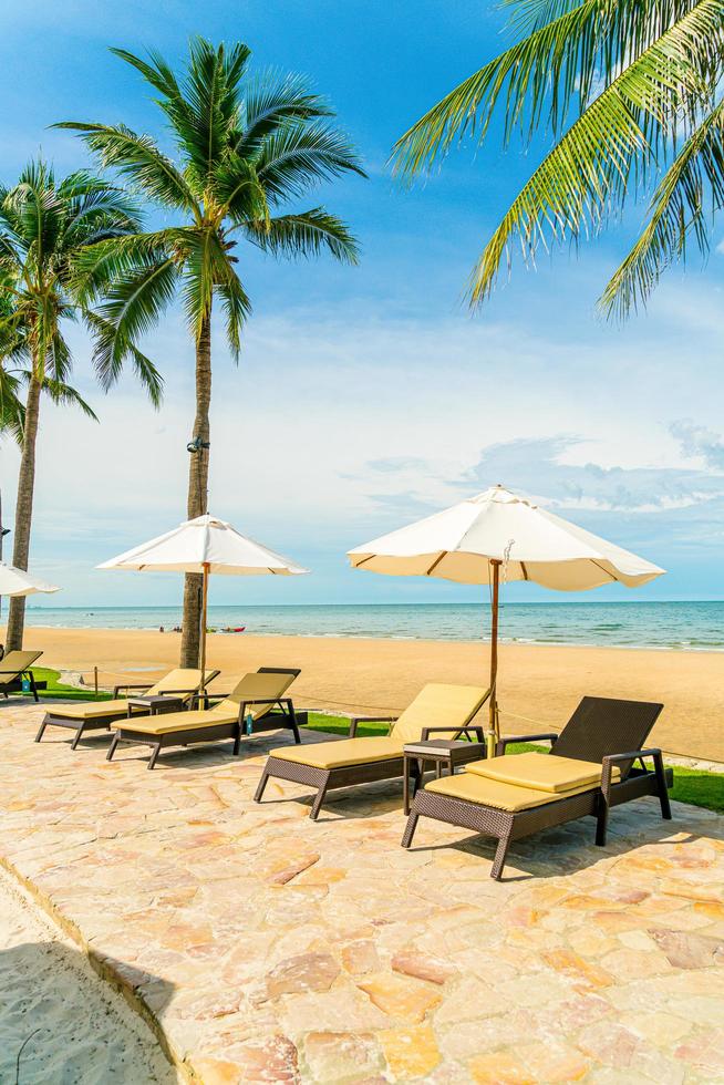 prachtig tropisch strand en zee met parasol en stoel rond zwembad in hotelresort foto