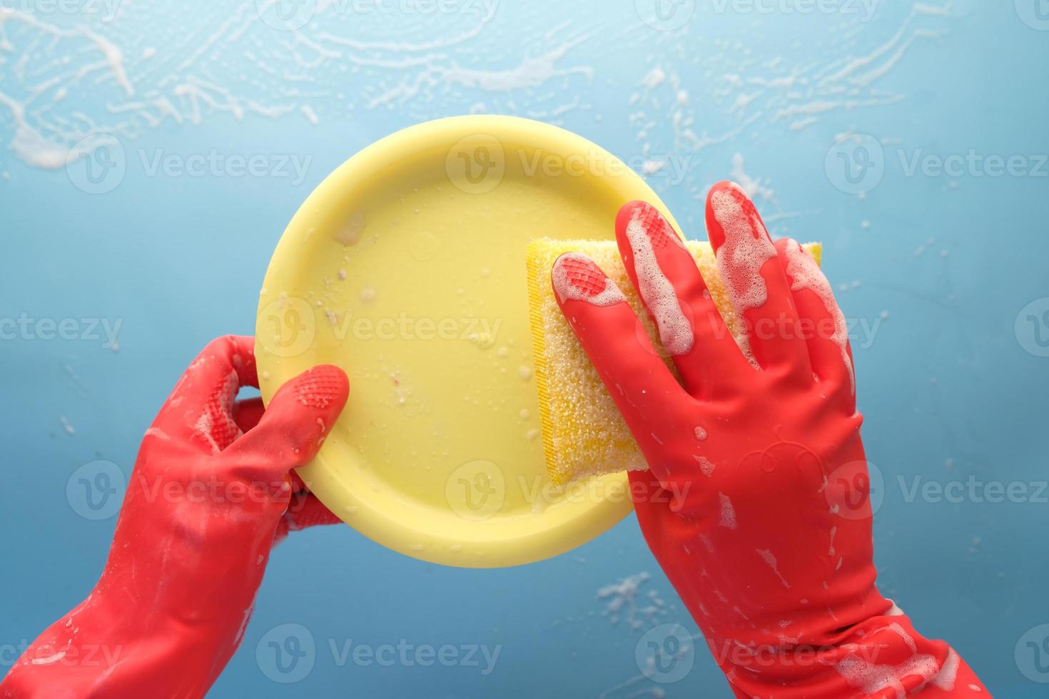 spons, rubberen handschoenen en kleurrijke plaat op blauw foto