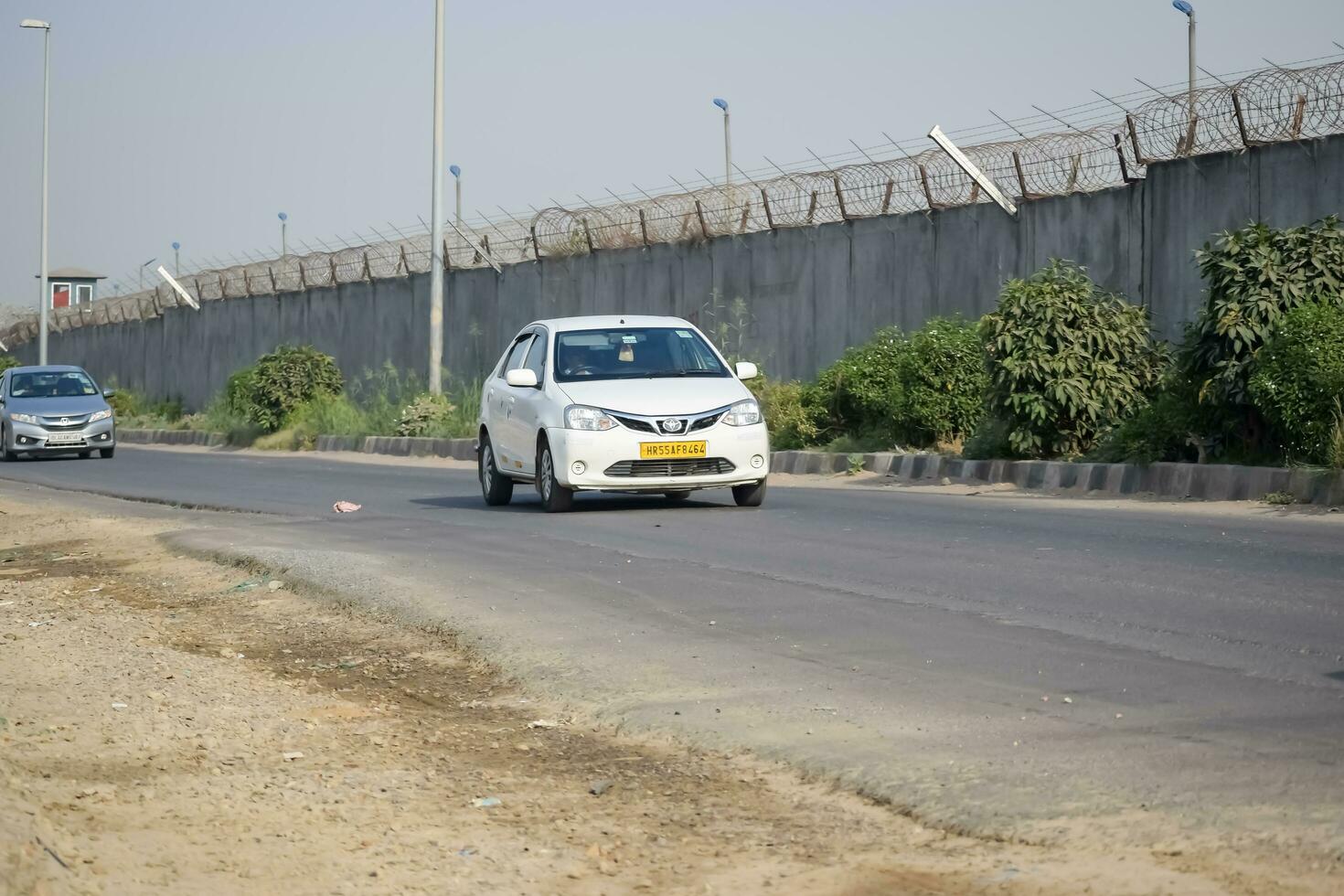 nieuw Delhi, Indië - april 16, 2023 - visie van voertuigen voorbijgaan door de hoofd weg in de buurt indra Gandhi Internationale luchthaven Delhi Bij dwerg koppeling weg foto