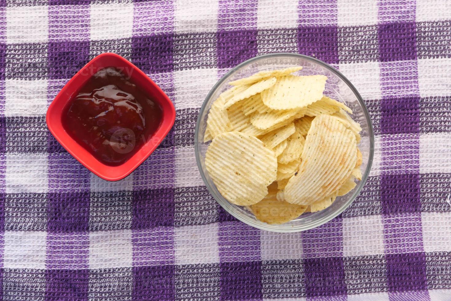 kom met lekkere chips op houten achtergrond. foto