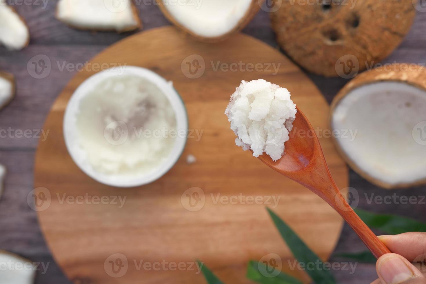 lepel met kokosolie en noot op zwarte achtergrond foto