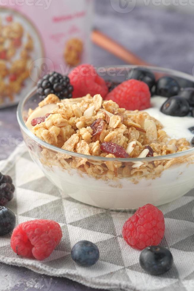 yoghurt, muesli en bessen in kom op houten achtergrond wooden foto