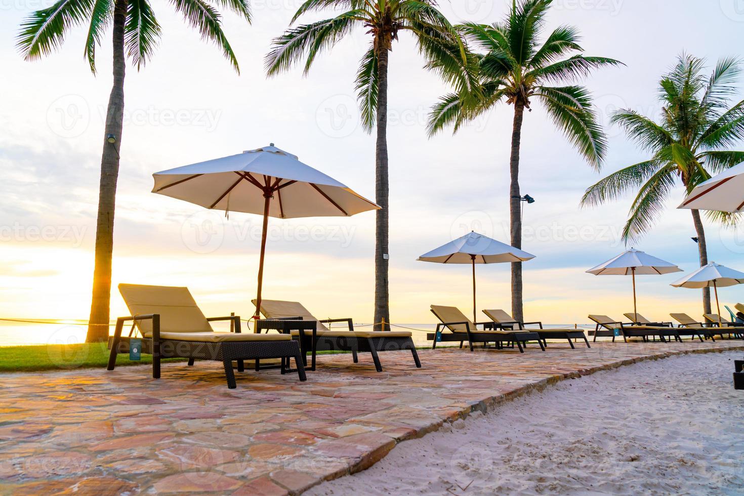 parasol en stoel rond zwembad in hotelresort met zonsopgang in de ochtend foto