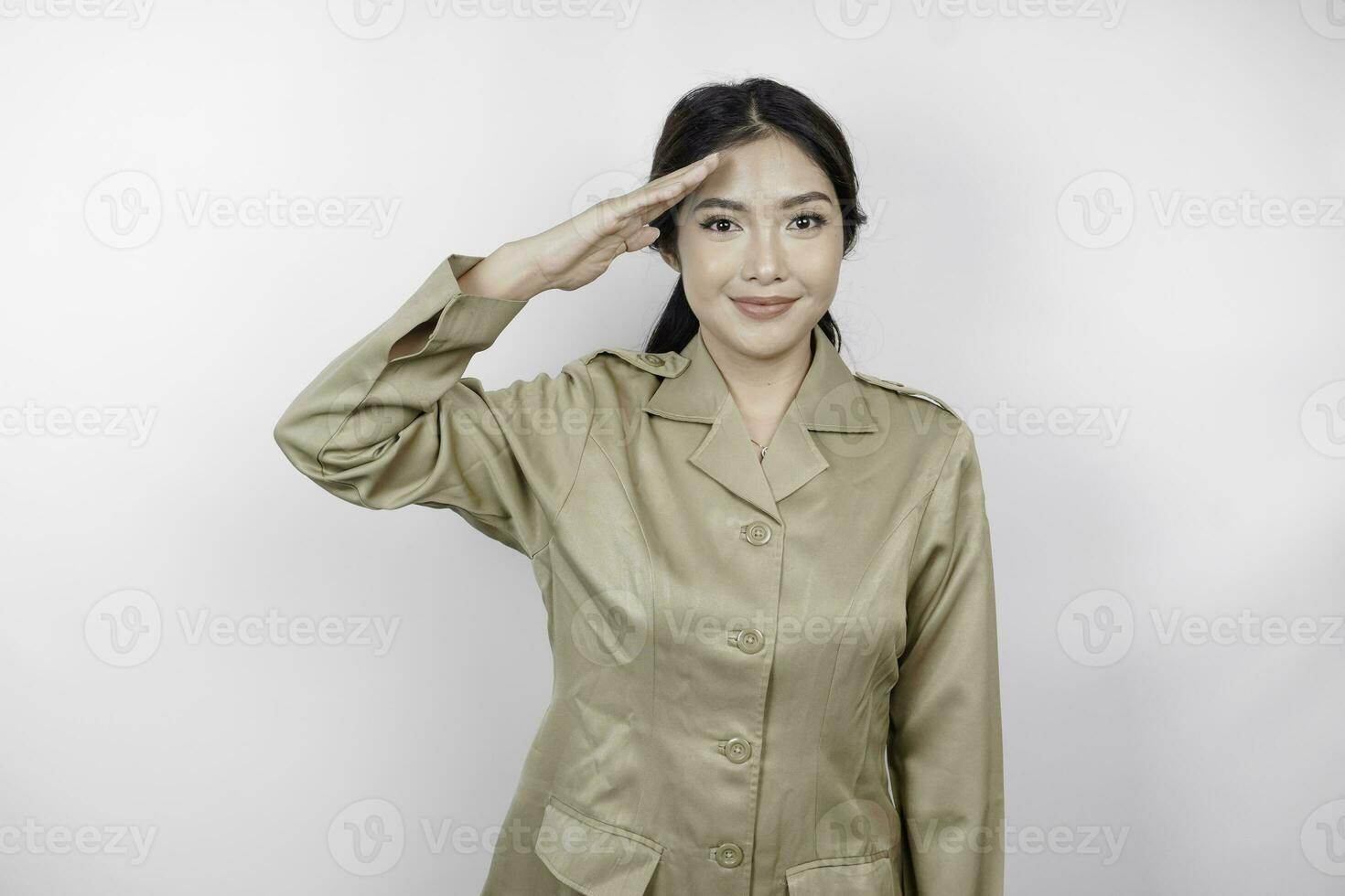 een jong Aziatisch regering arbeider vervelend een bruin uniform aan het doen groet houding, geïsoleerd door wit achtergrond foto