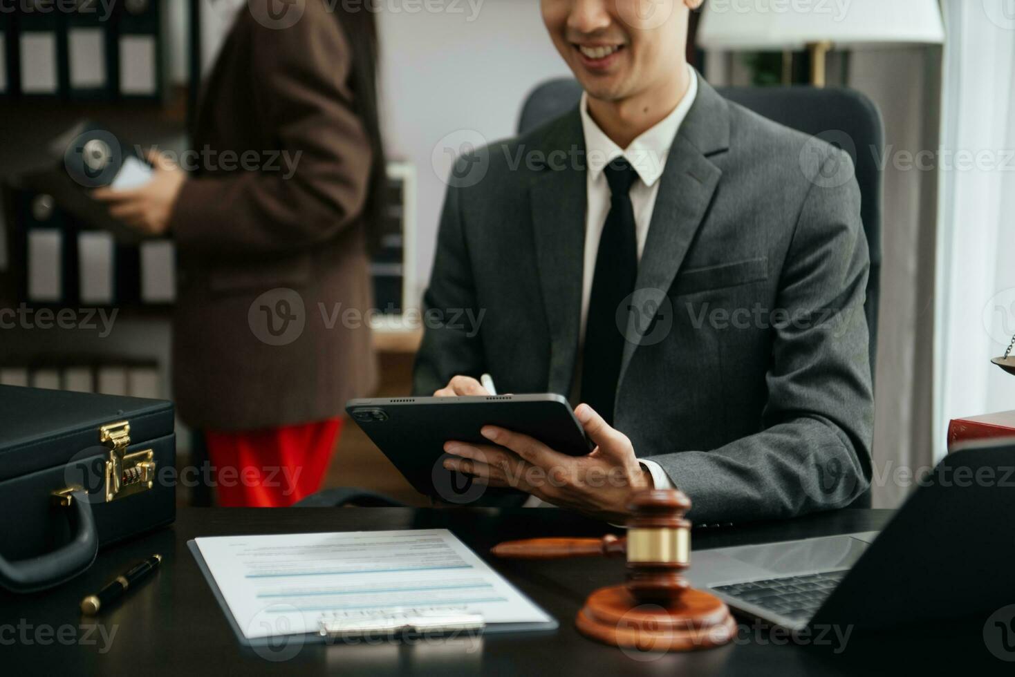 gerechtigheid en wet concept.wet thema houten bureau, boeken, evenwicht. mannetje rechter in een rechtszaal de hamer, werkend met digitaal tablet computer Aan tafel foto