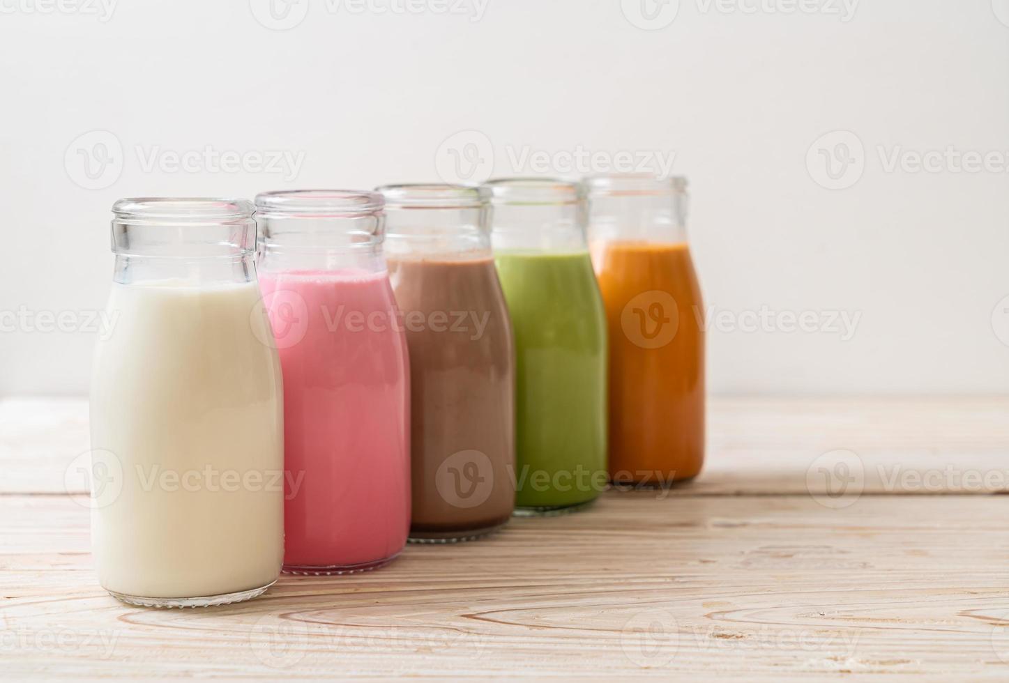 thaise melkthee, matcha groene thee latte, koffie, chocolademelk, roze melk en verse melk in fles foto