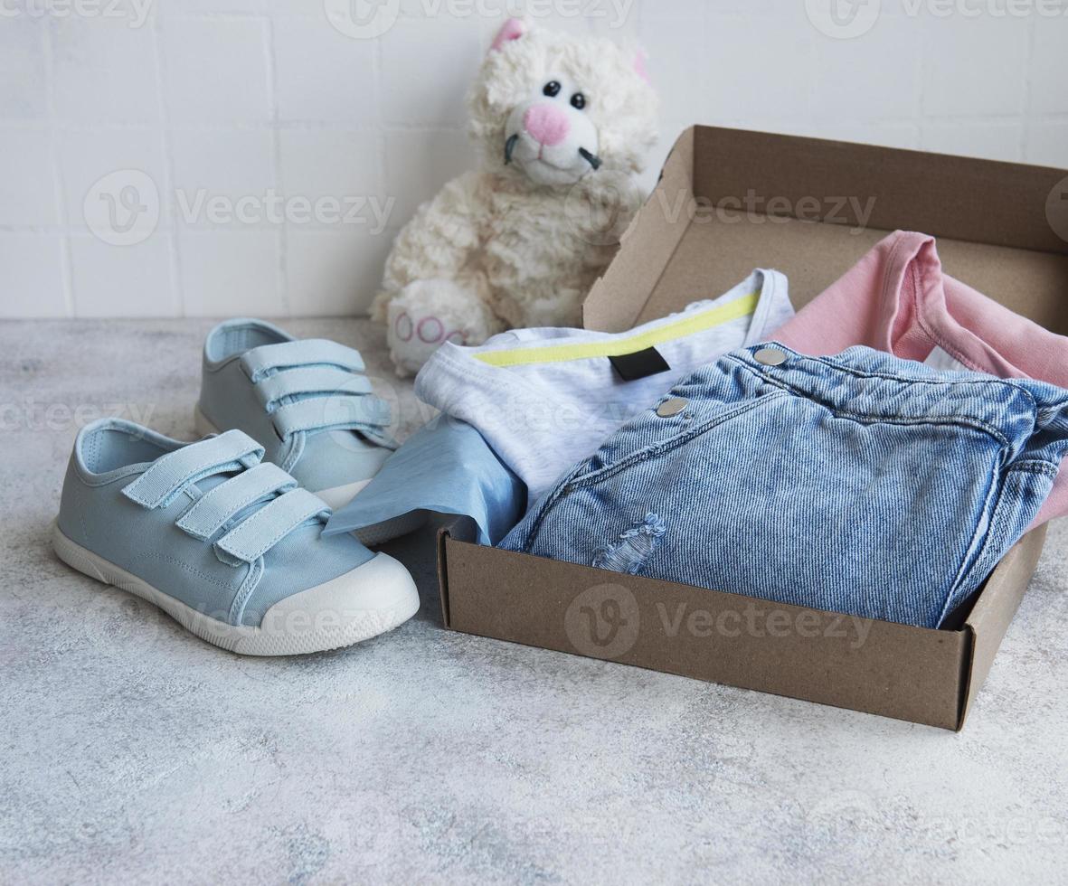 kledingspar kinderen in een open kartonnen doos foto