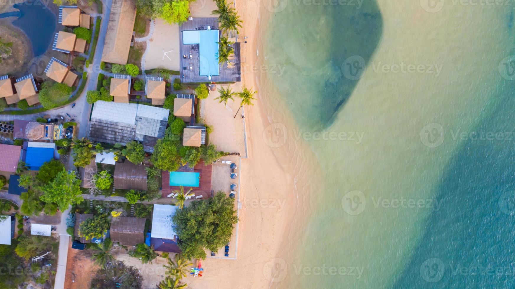 bovenaanzicht vanuit de lucht, resort en strand met smaragdblauw water op prachtige tropische zee in thailand foto