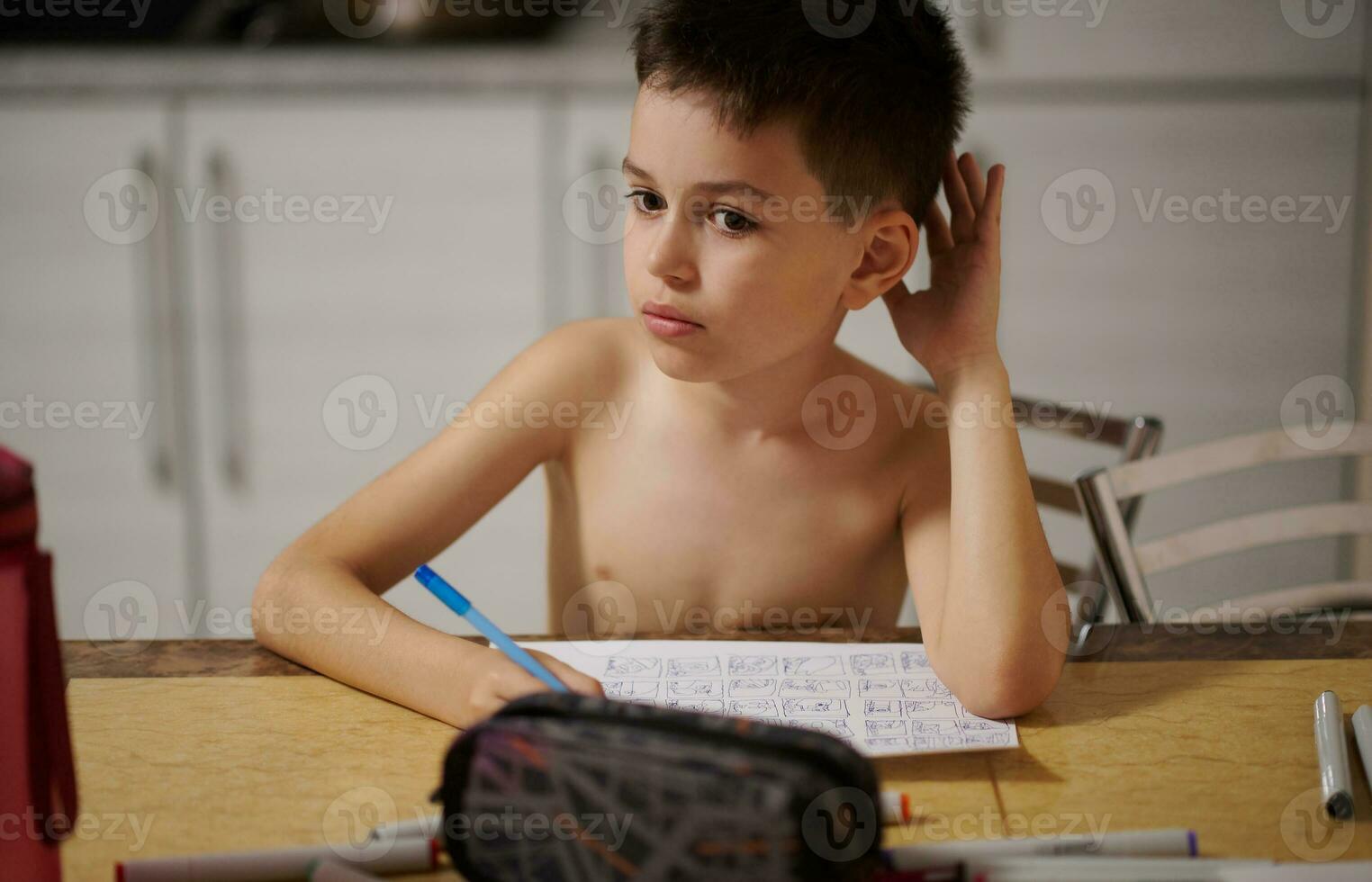 de tekening jongen looks bedachtzaam terzijde zit Bij de tafel in de keuken foto