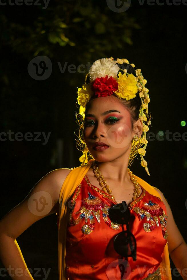 een Javaans danser poses met scherp ogen en een gouden kostuum Aan stadium foto