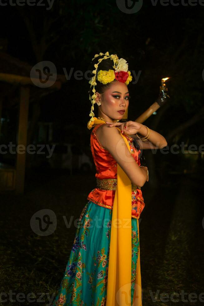 een Javaans danser poses met scherp ogen en een gouden kostuum Aan stadium foto