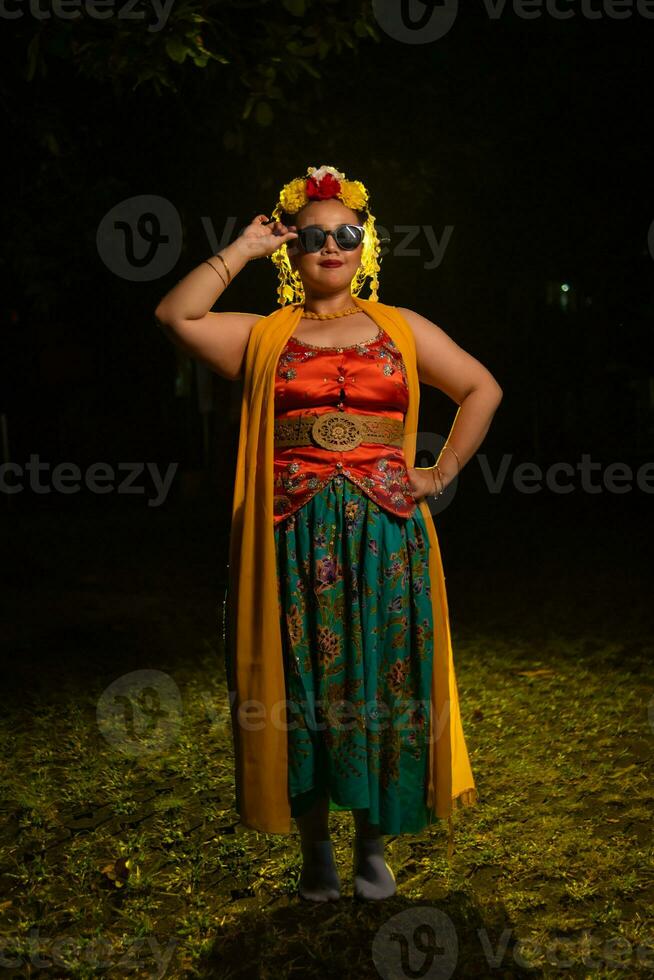 een portret van een Indonesisch danser met jasmijn bungelend in haar haar- siert haar mooi uiterlijk Aan stadium foto