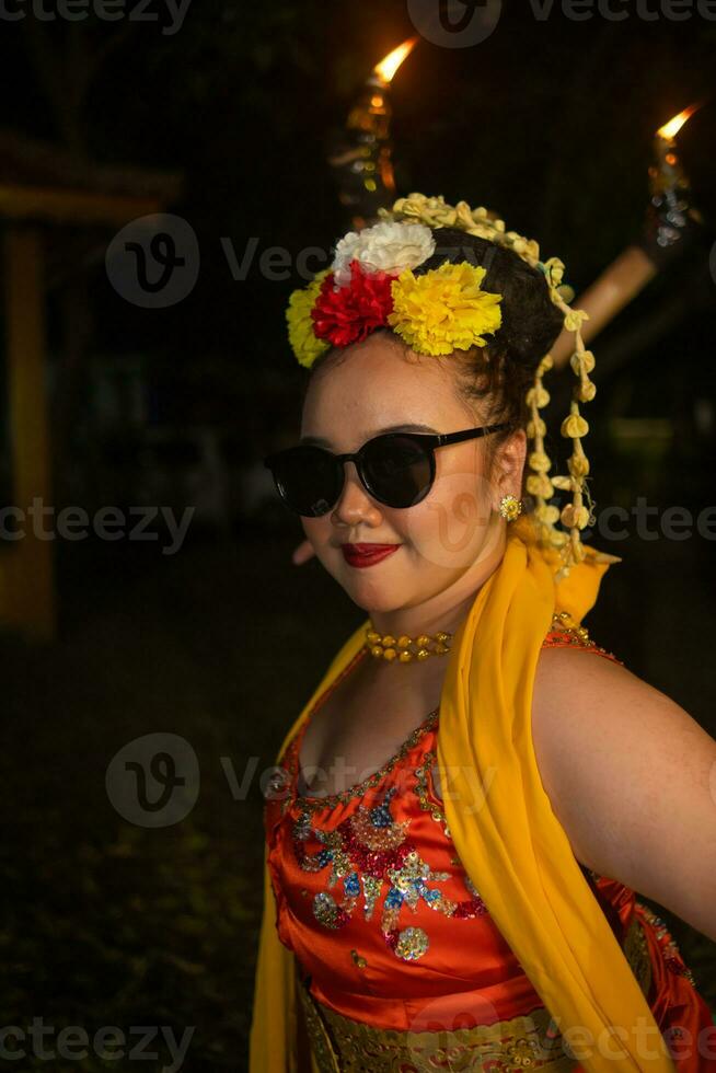 een portret van een Indonesisch danser met jasmijn bungelend in haar haar- siert haar mooi uiterlijk Aan stadium foto