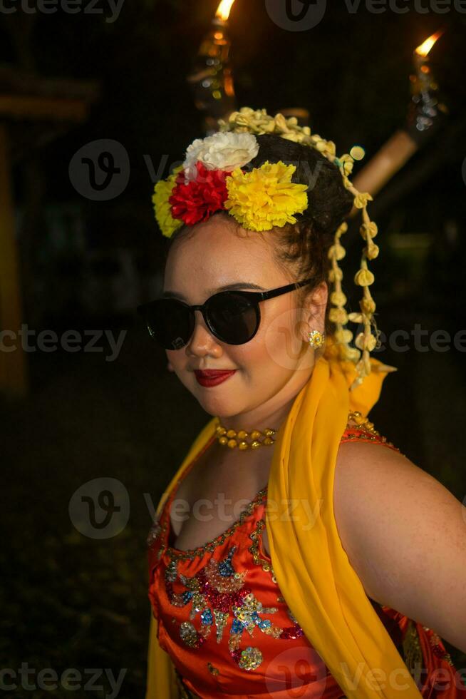 een portret van een Indonesisch danser met jasmijn bungelend in haar haar- siert haar mooi uiterlijk Aan stadium foto