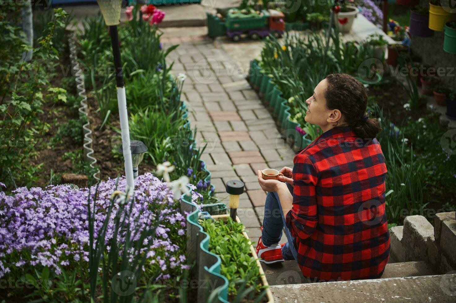 mooi volwassen spaans vrouw tuinman resting in de tuin buiten land huis. de concept van een kalmte buitenshuis recreatie buiten de stad foto