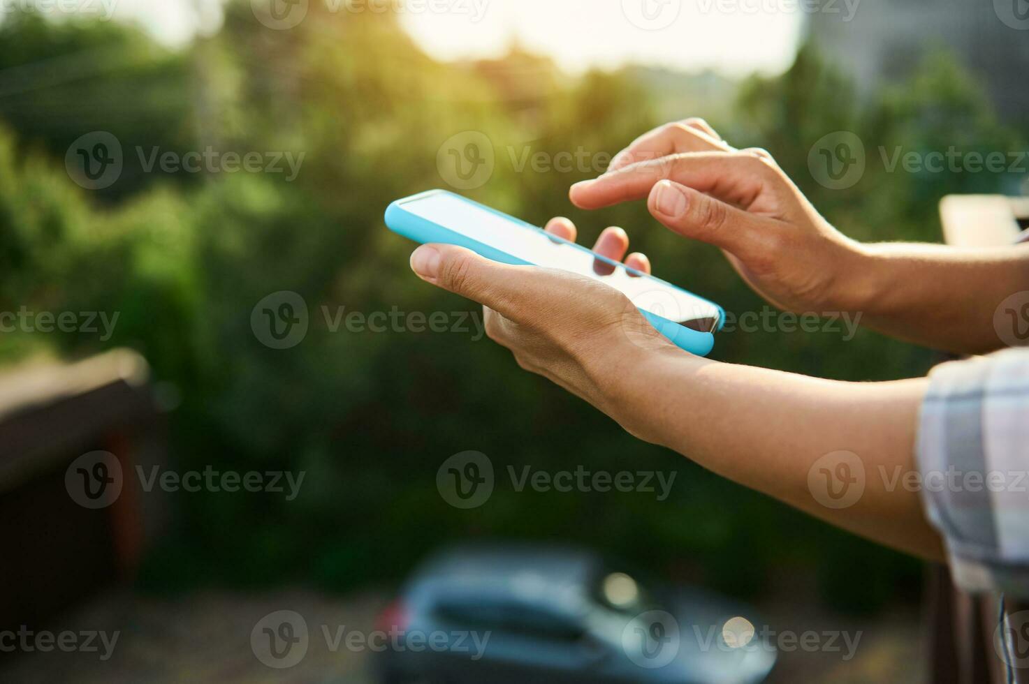 detailopname van vrouw handen Holding mobiel telefoon tegen zonlicht achtergrond foto