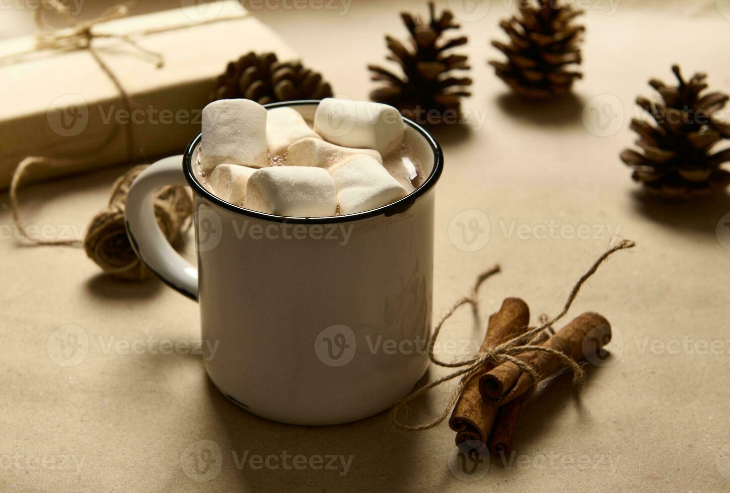 gebonden kaneel in boog van een touw De volgende naar gemakkelijk rustiek oud kop van heet cacao drinken en wit zoet marshmallows Aan een karton achtergrond met pijnboom kegels en Kerstmis geschenk in ambacht omhulsel papier foto