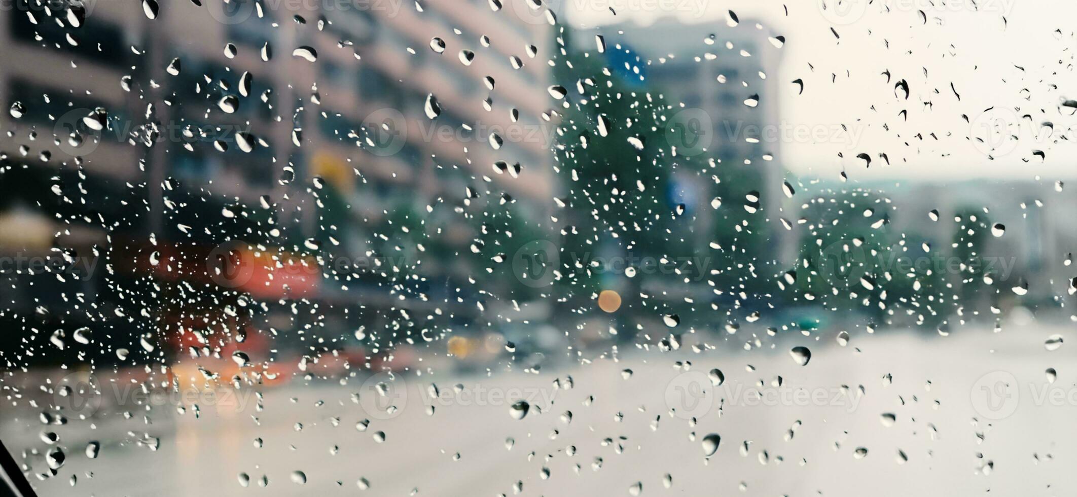 regen douche Aan auto voorruit of auto venster en wazig weg in achtergrond. foto