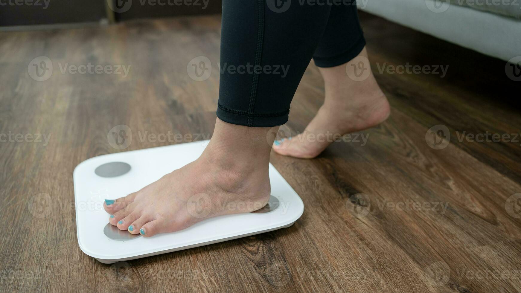 voeten staand Aan elektronisch balans voor gewicht controle. meting instrument in kilogram voor een eetpatroon controle foto