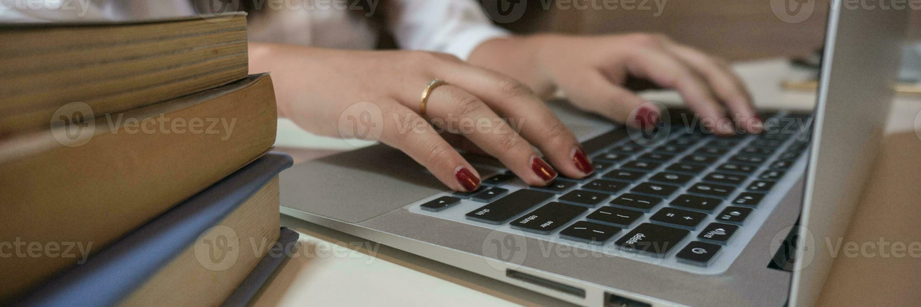 werken door gebruik makend van een laptop computer Aan houten tafel. handen typen Aan een toetsenbord. foto