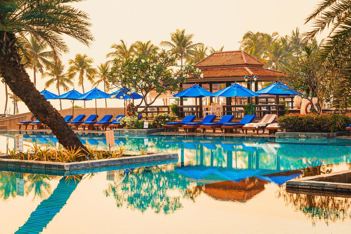 mooie parasol en stoel rond zwembad in hotel en resort foto