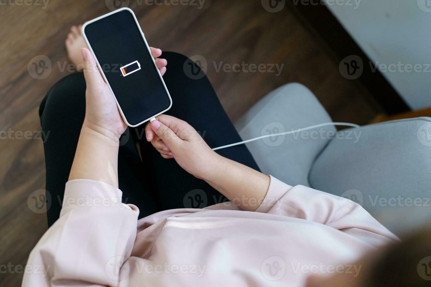 vrouw handen opladen mobiel telefoon accu met laag accu. aansluiten een oplader in een slim telefoon met energie bank powerbank macht oplader modern levensstijl energie technologie concept foto