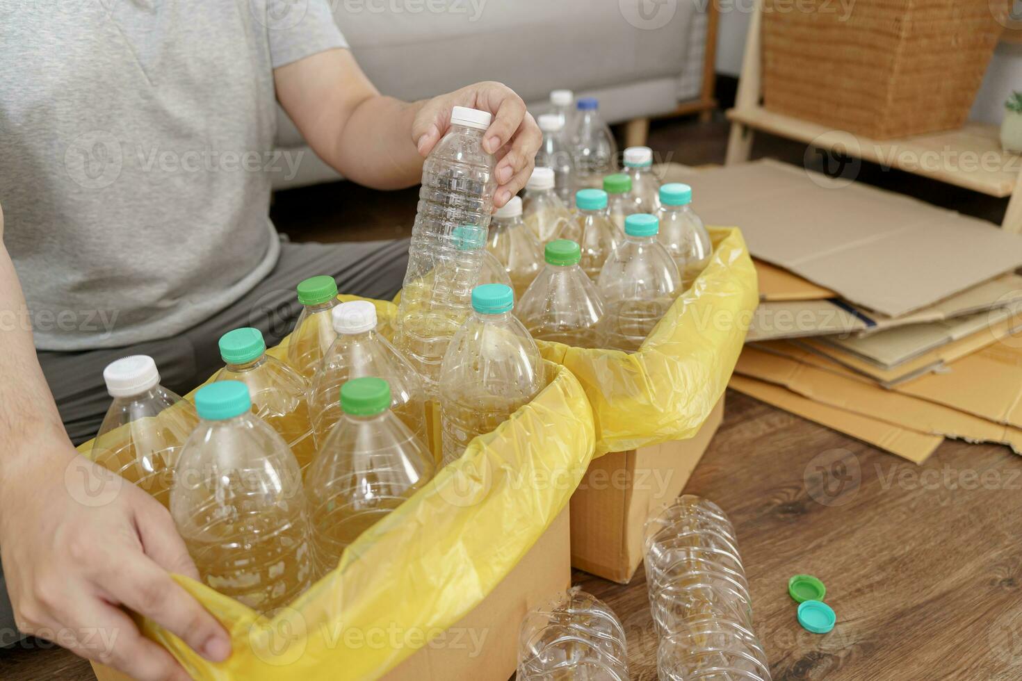 huis recycle eco groen nul concept Mens het werpen leeg plastic fles in recycling bak met geel vuilnis Tassen Bij huis foto