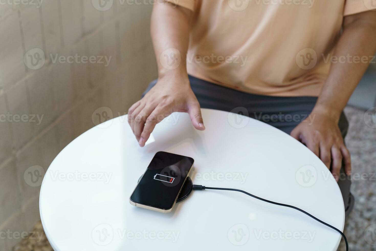 opladen mobiel telefoon accu met draadloze opladen apparaat in de tafel. smartphone opladen Aan een opladen kussen. mobiel telefoon in de buurt draadloze oplader modern levensstijl technologie concept. foto