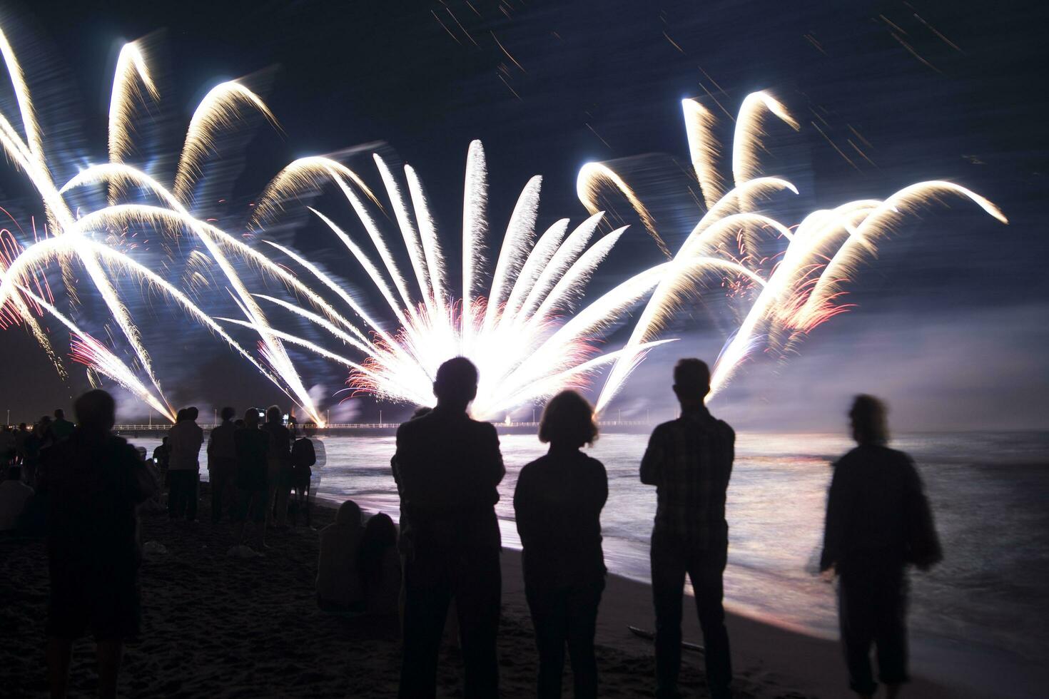 mensen aan het kijken vuurwerk Aan de strand foto