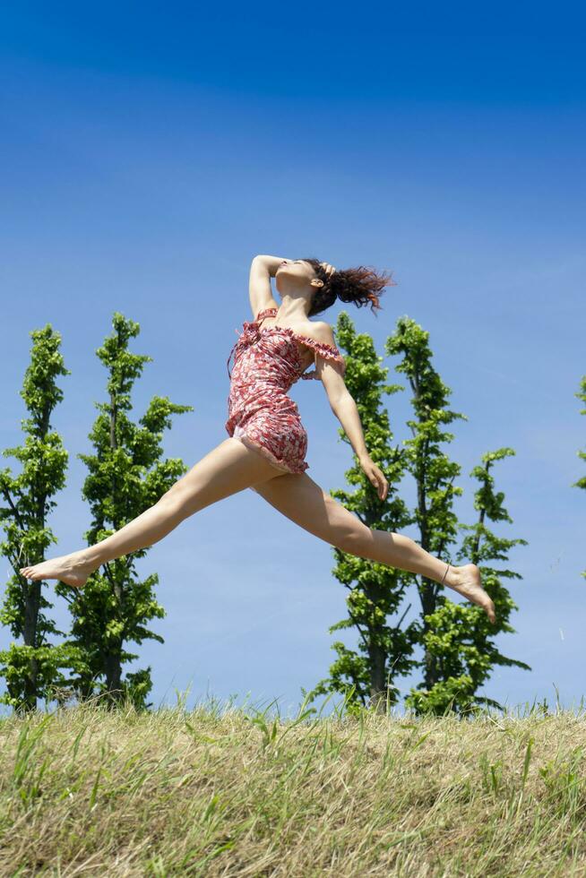 meisje jumping in natuur in voorjaar seizoen foto