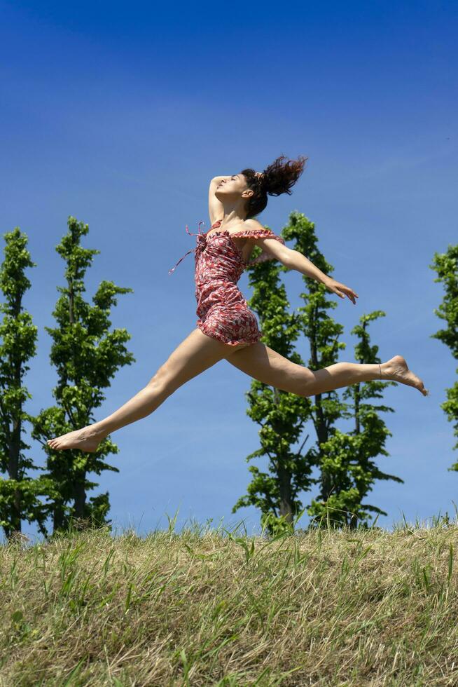meisje jumping in natuur in voorjaar seizoen foto