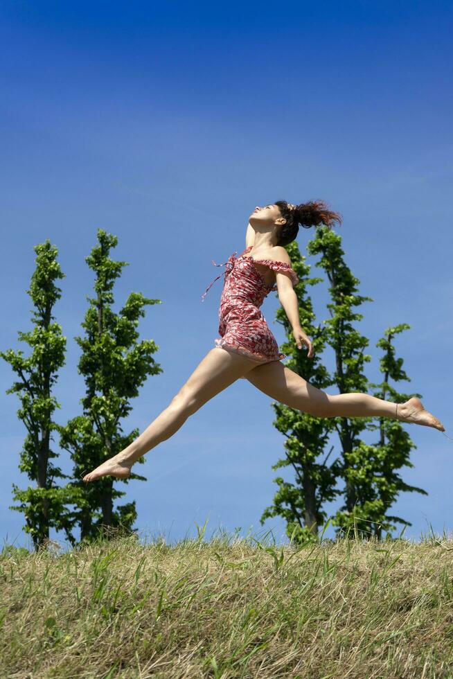 meisje jumping in natuur in voorjaar seizoen foto