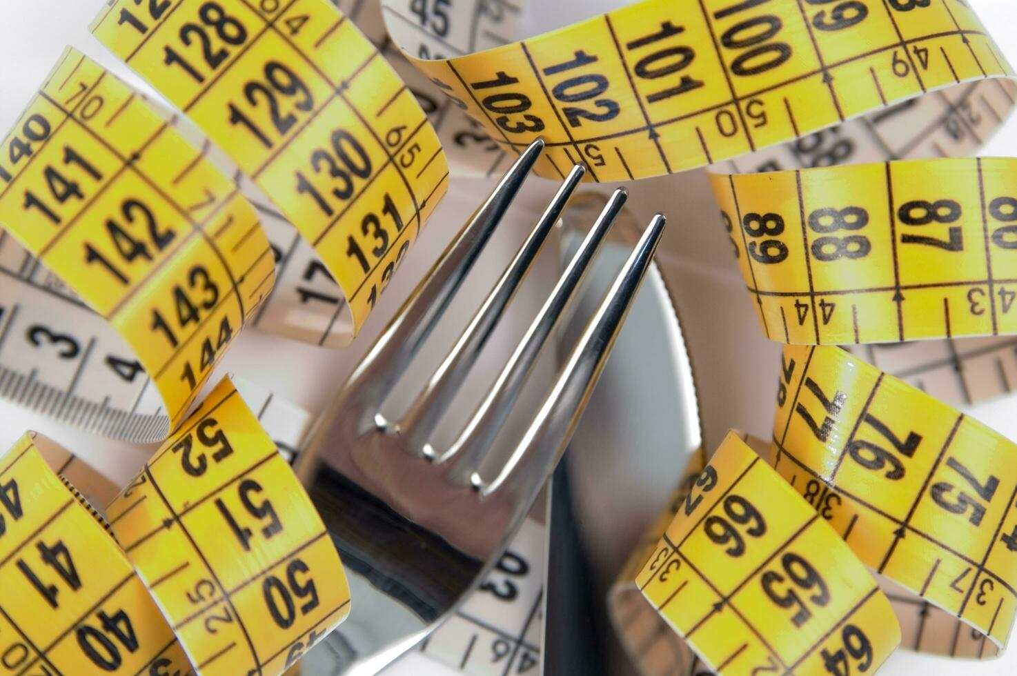 een vork en mes omringd door meten plakband foto