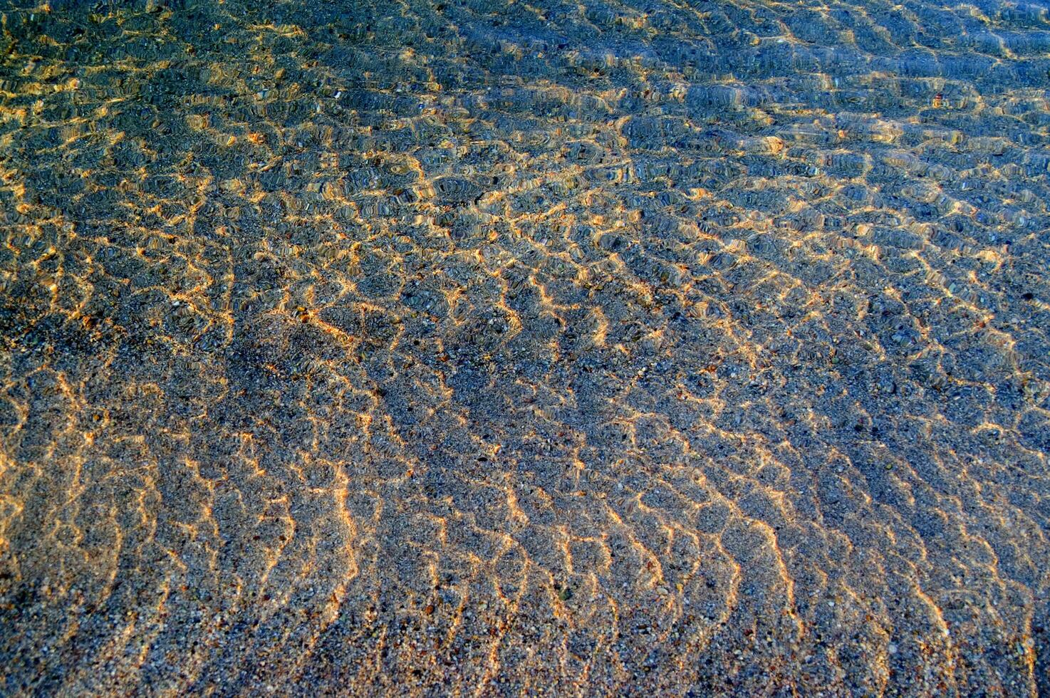 de water is Doorzichtig en blauw met zand foto
