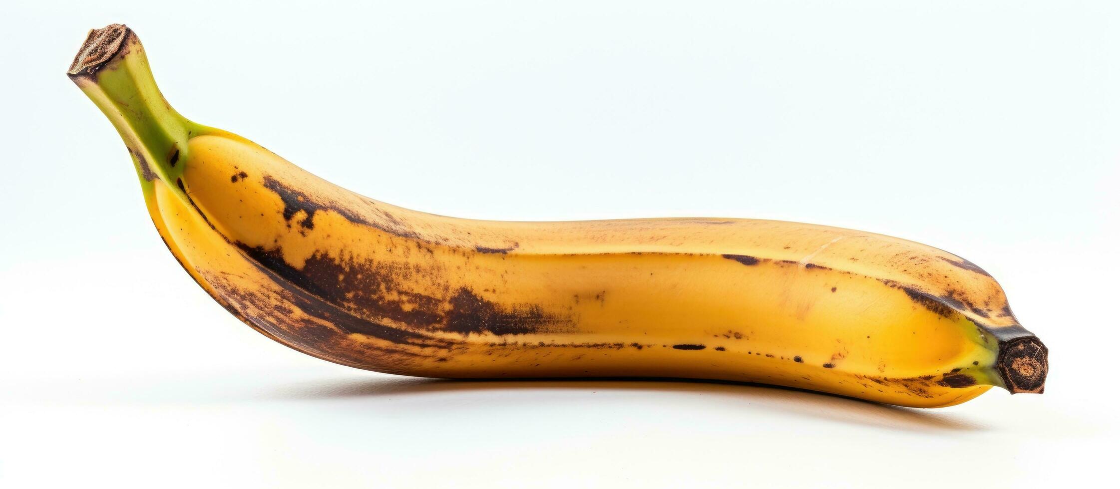 een banaan dat is verwend en zwart kan worden gezien Aan een wit achtergrond. het heeft een bruin plek en is foto