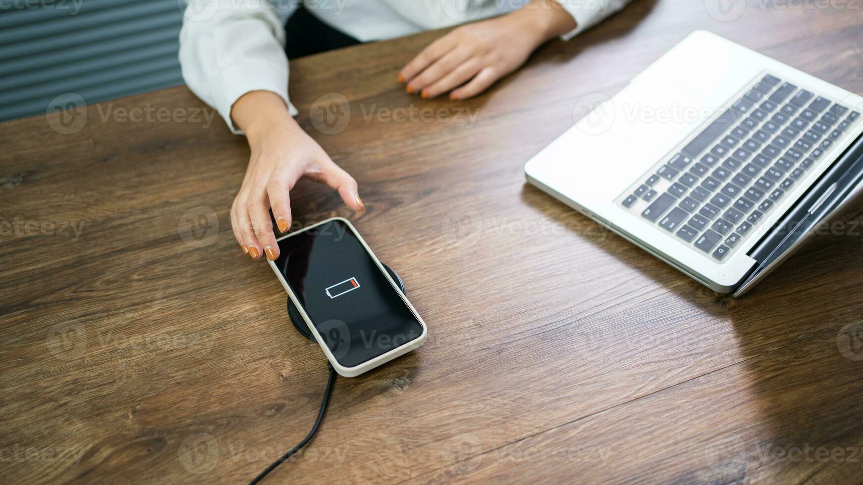 opladen mobiel telefoon accu met draadloze opladen apparaat in de tafel. smartphone opladen Aan een opladen kussen. mobiel telefoon in de buurt draadloze oplader modern levensstijl technologie concept. foto