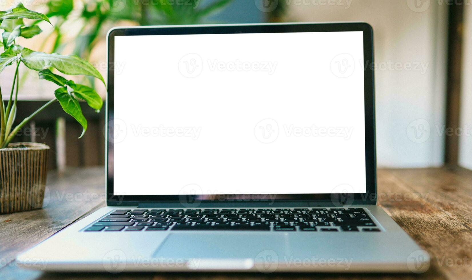 laptop met bespotten omhoog blanco scherm Aan houten tafel in voorkant van cafe ruimte voor tekst. Product Scherm computer laptop montage- technologie concept. foto