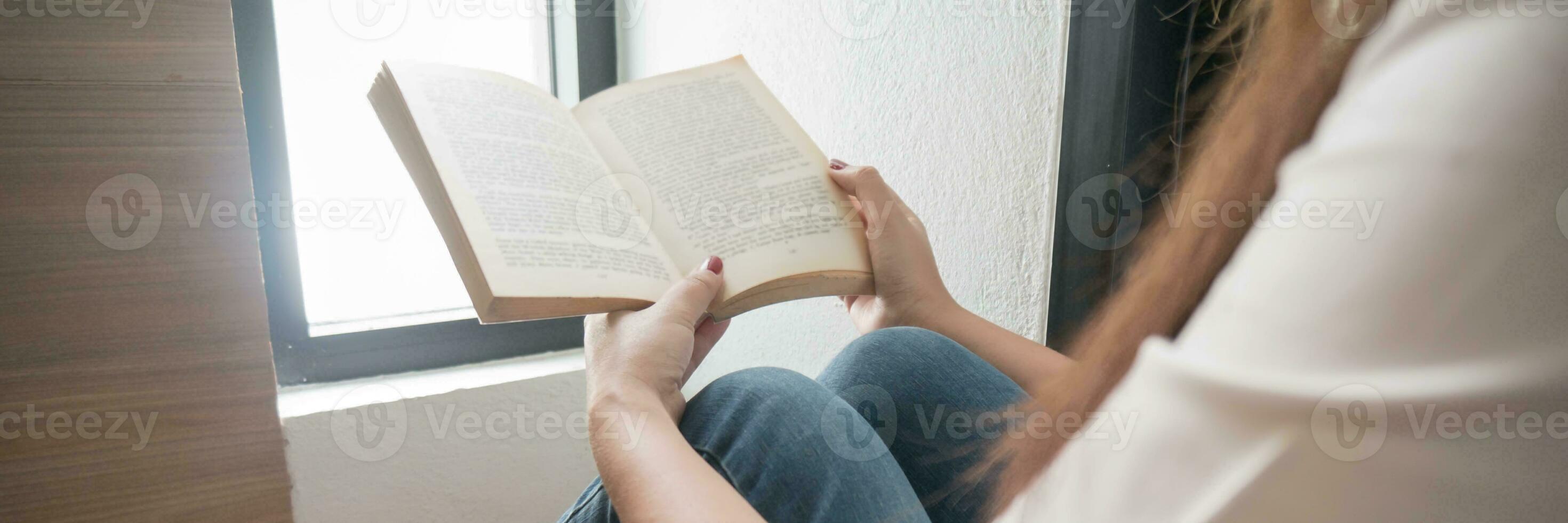 Dames lezing boek en ontspannende Bij huis en comfort in voorkant van geopend boek. foto