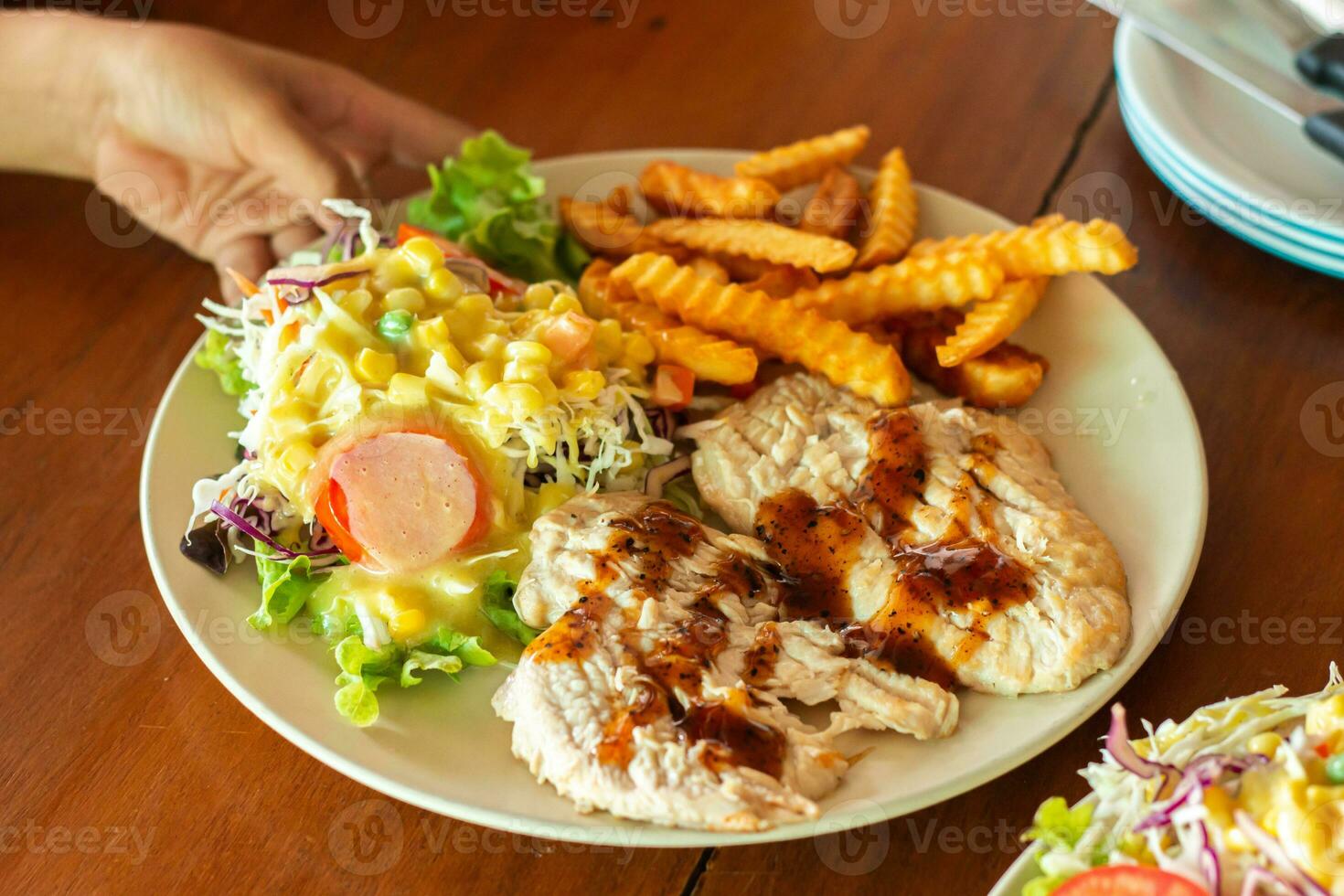 heerlijk steak met Patat en salade in een gerecht. ,hand Holding een bord foto